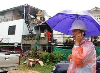 A city official inspects property in South Pattaya for signs storm damage.